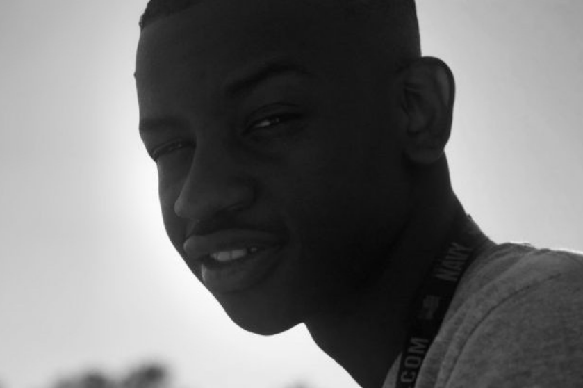 A black and white portrait shows Kevin Kafuku smiling at the camera.