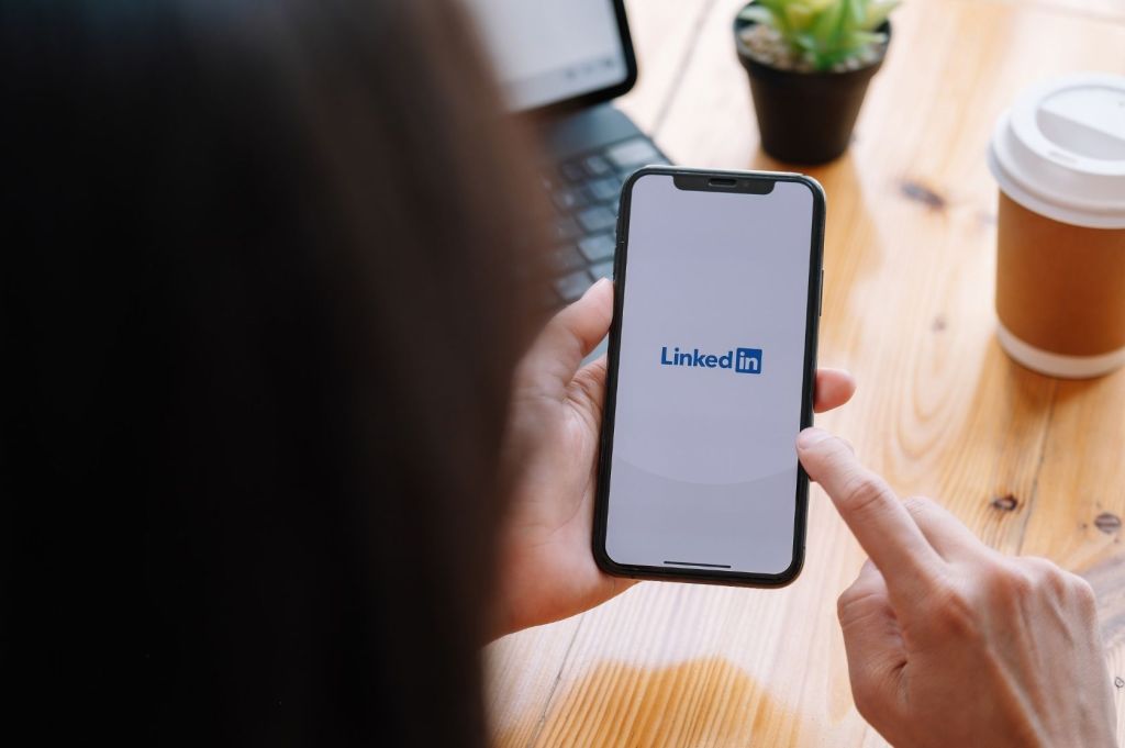 Woman logs into LinkedIn from phone.