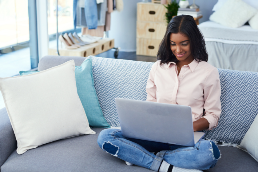 woman on couch working on a computer